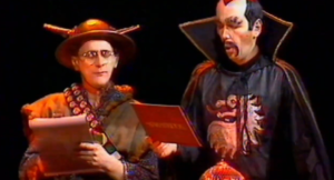 Two characters reading from card while in costumes