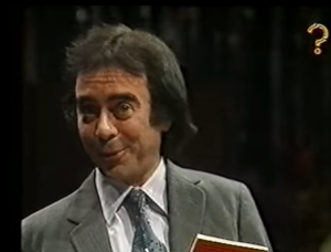 Man holding a book making eye contact with the camera