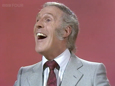 Host laughing looking into the distance away from the camera