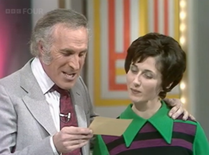 Host and contestant reading from a card