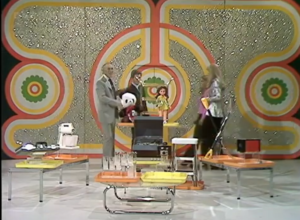 Host behind tables with prizes