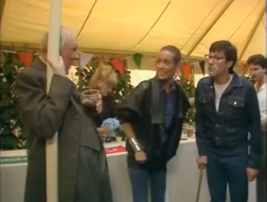 Screenshot from episode 2 characters under a tent