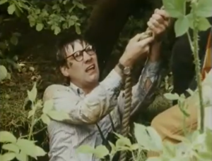 Screenshot from episode 3 of Ansell stuck in a hole while holding onto a rope